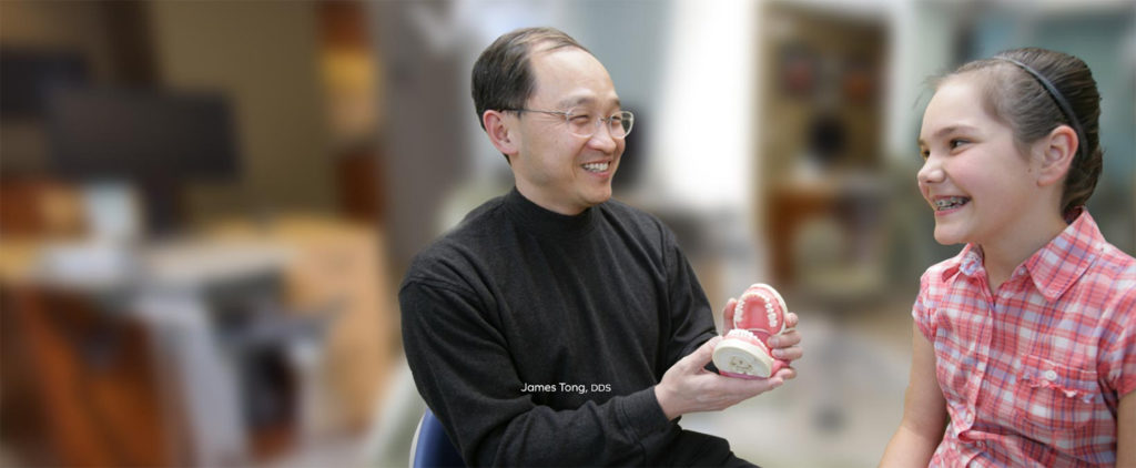 Dr. Tong showing fake teeth to a child