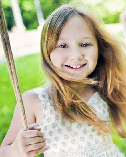 Little girl on swing smiling