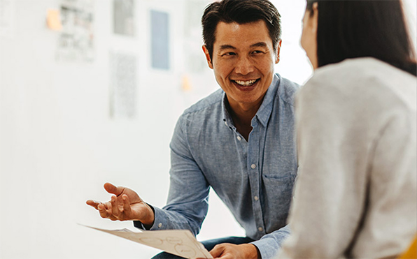 Man smiling while talking to a woman