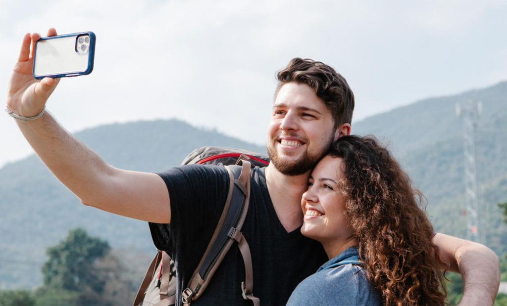 Two people smiling and taking a picture in nature