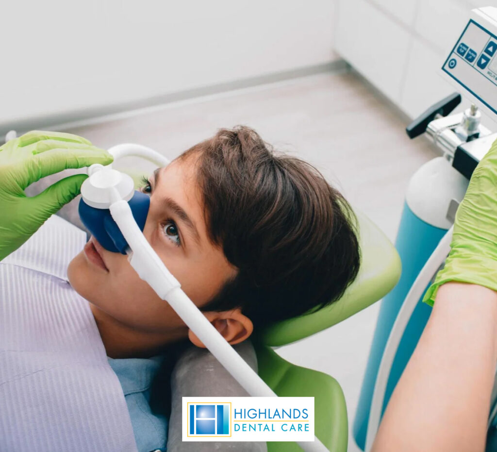 A young boy reclining in a dental chair, undergoing sedation while a dentist performs a dental procedure.